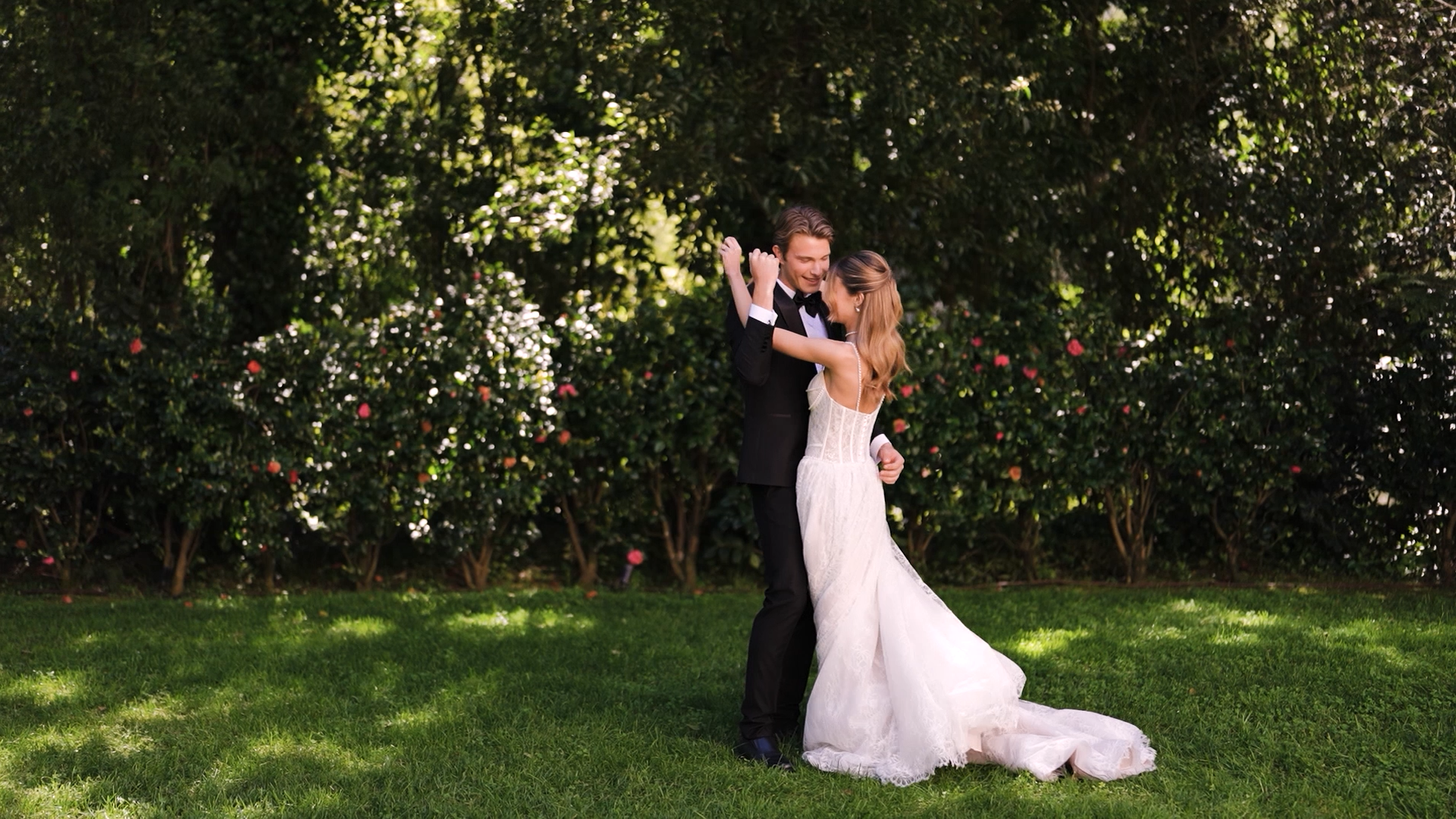 Bride and groom dancing together in a garden